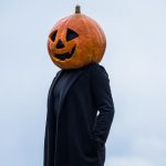 A person in a Halloween pumpkin head costume outdoors in Guasca, Colombia.